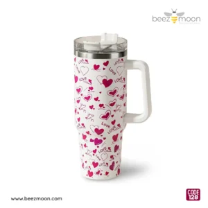 Professional product photography of a Beezmoon white insulated tumbler with a red heart and "LOVE" pattern, featuring a sturdy white handle and clear lid (Code 128).